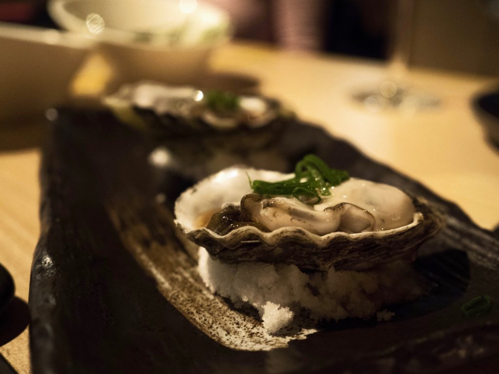 A raw oyster sitting on a bed of salt