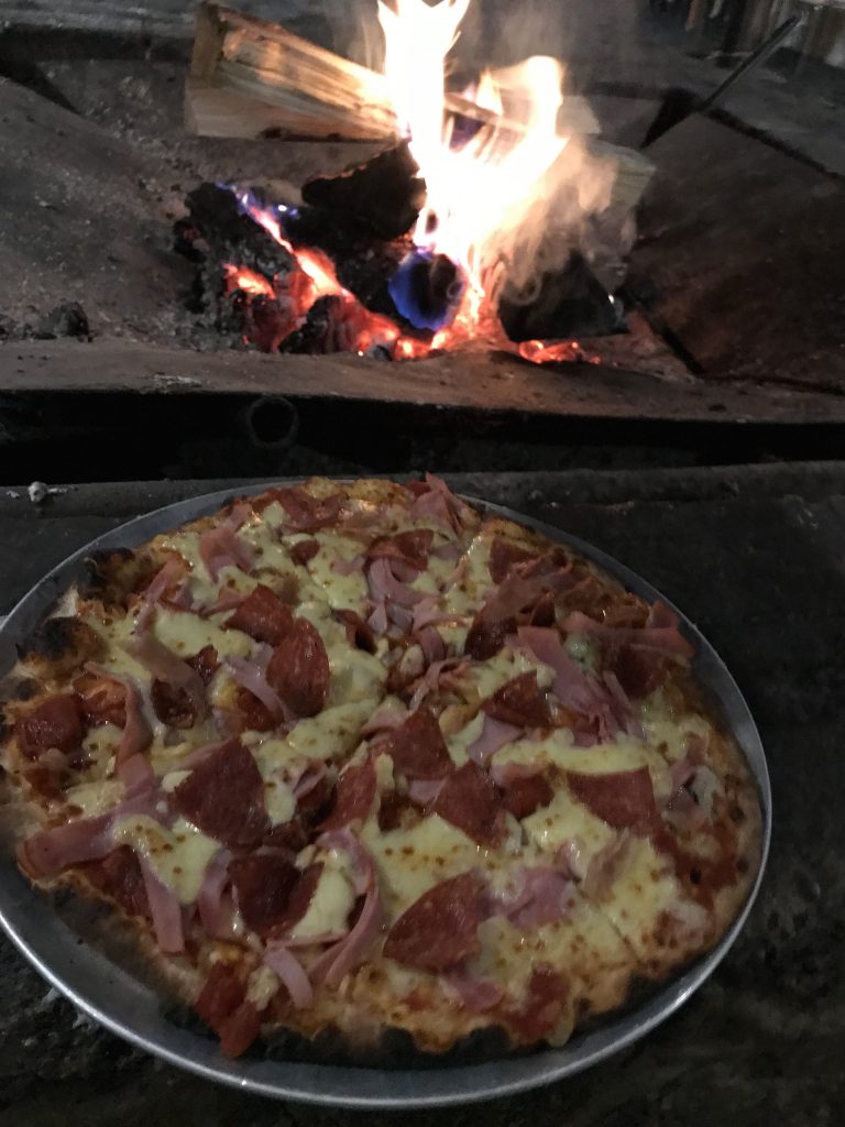 Meat lovers pizza by the fire at Corin Forest